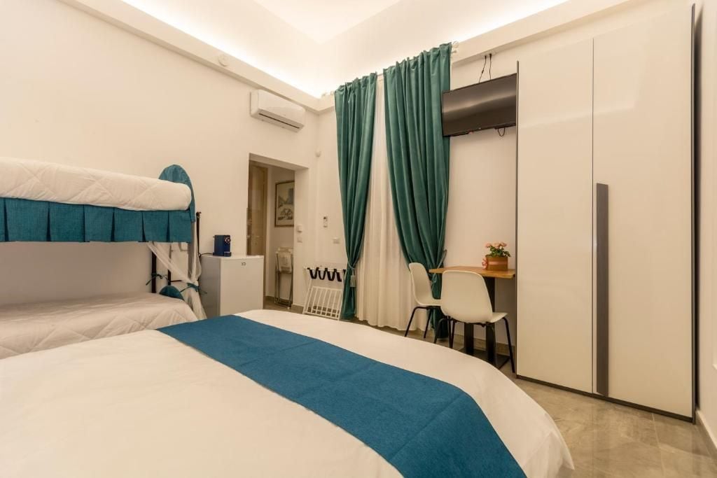 Une chambre d’hôtel avec un lit, un bureau, une chaise et une armoire.
