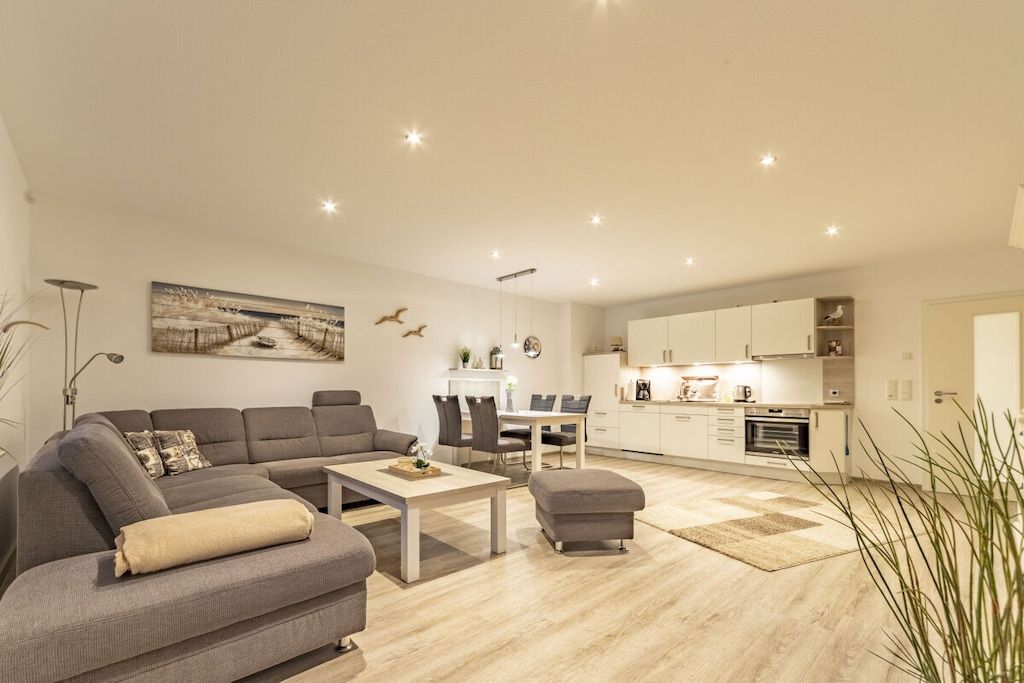 A modern living room with a sofa, coffee table, and dining area.