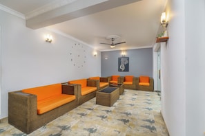A room with wicker furniture, a ceiling fan, and a clock on the wall. - Hotel TravllersNest Kandy (Kandy)