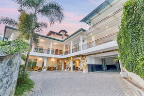 A hotel with a spacious courtyard, multiple balconies, and lush greenery. - Hotel TravllersNest Kandy (Kandy)