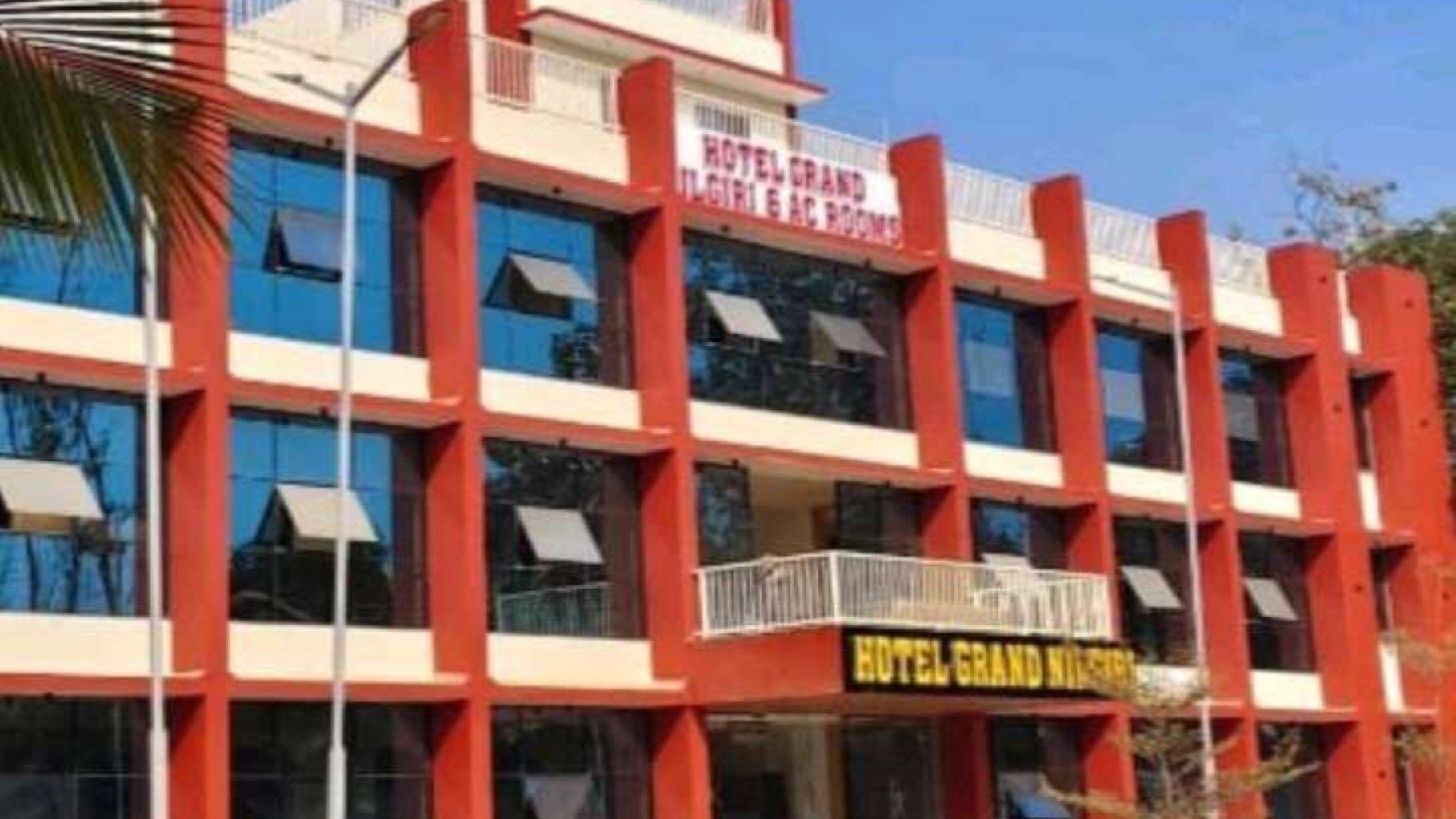 Un edificio de hotel de varios pisos con balcones y señalización que indica que es un hotel.