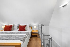 A modern bedroom with a bed, nightstands, and a metal handrail. - Friesenhaus for 2 – A Little Getaway, Big Holiday Happiness by the Baltic Sea (Schönberg (Holstein))