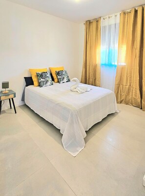 A neatly made bed with a white bedspread and a decorative swan-shaped towel. - KAz Bel Horizon welcomes you for a stay on this paradise island. (Saint-Leu)