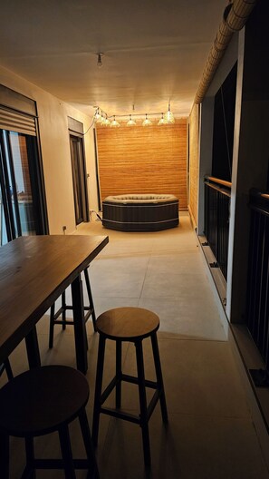 A modern interior with a long wooden table, two stools, a round seating area, and a wall with a wooden panel. - KAz Bel Horizon welcomes you for a stay on this paradise island. (Saint-Leu)