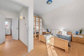 Un dormitorio moderno con una cama grande, dos mesitas de noche, un armario y una lámpara de techo.