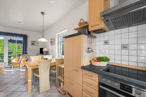 Eine moderne Küche mit Backofen und einem Essbereich, inklusive Tisch und Stühlen.