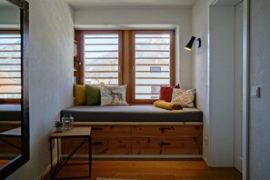 Ein gemütliches Zimmer mit einer eingebauten Bank, einem kleinen Tisch und einer Wandlampe.