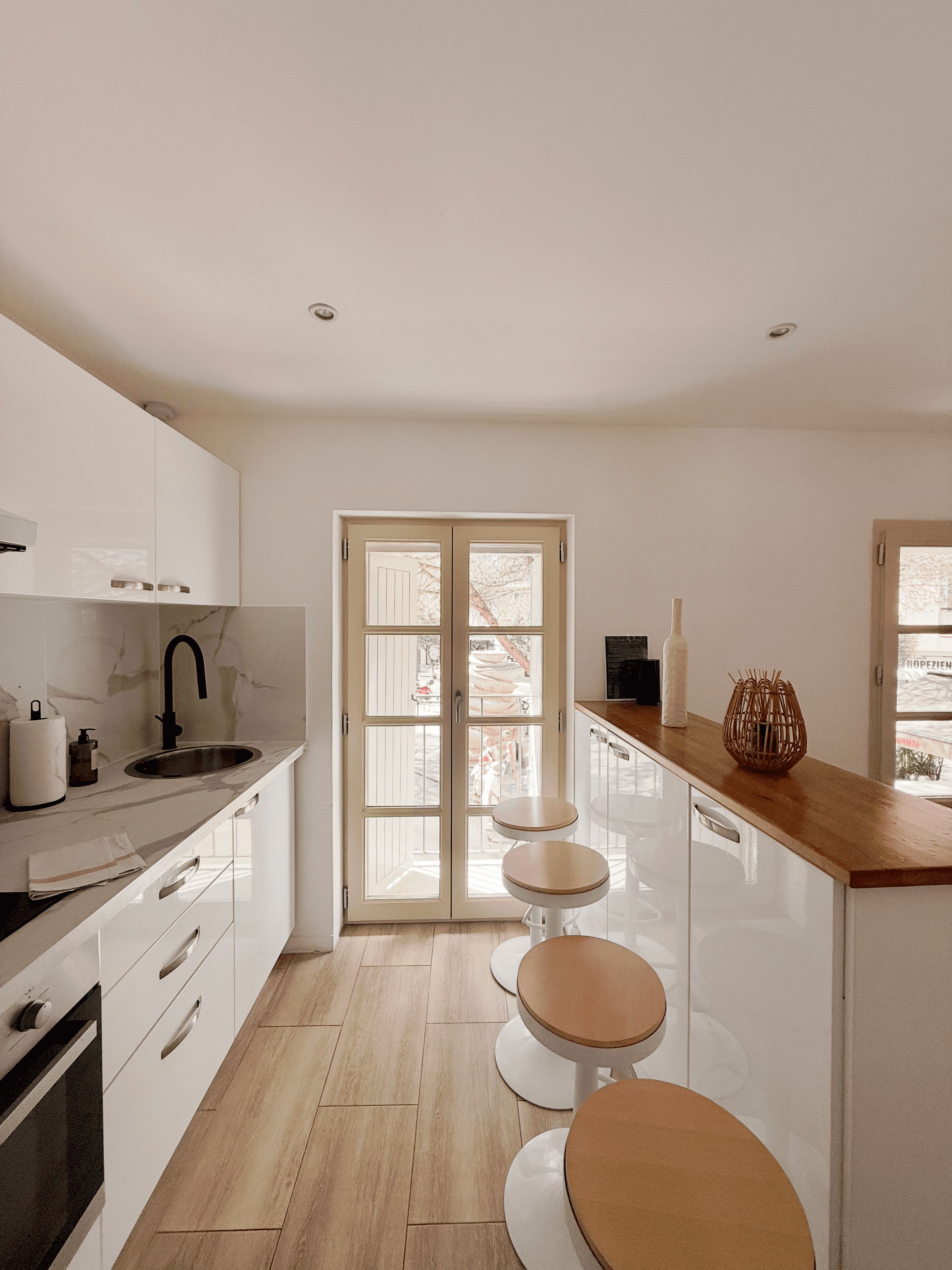 Una cocina moderna con una isla central, un doble acceso al exterior y vistas al aire libre.