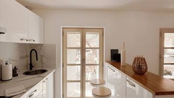 Una cocina moderna con una isla central, un doble acceso al exterior y vistas al aire libre.