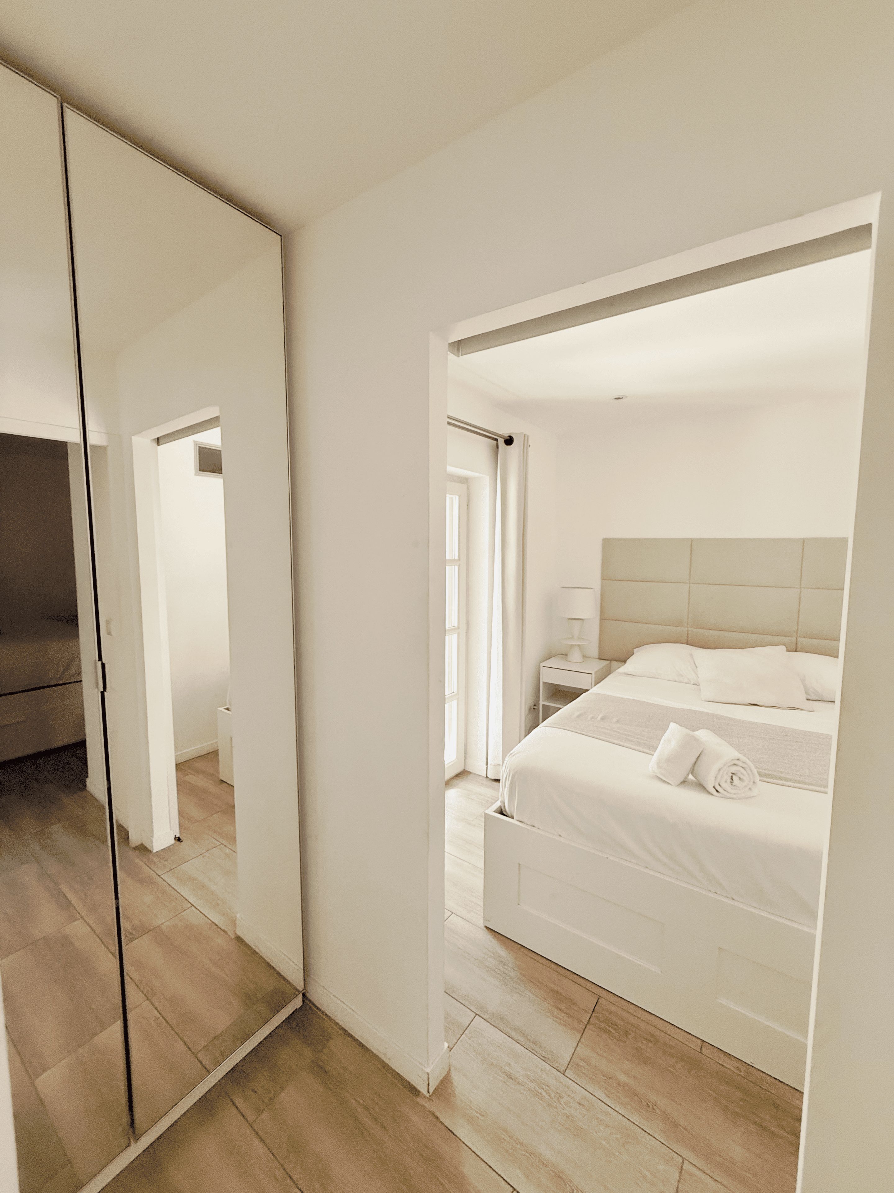 Une chambre à coucher avec un lit, une table de chevet et un miroir.