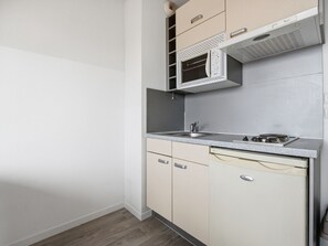 A compact kitchen with a built-in microwave, a sink, and a stove. - Studio with swimming view and nature view (Grasse)