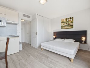 A modern bedroom with a bed, bedside tables, a desk, and a chair. - Studio with swimming view and nature view (Grasse)