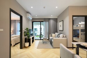 Une chambre d’hôtel moderne équipée d’un lit, d’un canapé, d’une table à manger et d’un balcon avec vue.