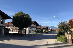 A street view with traditional buildings, a clear sky, and mountains in the background. - Apartment Unterbergblick (Reit im Winkl)