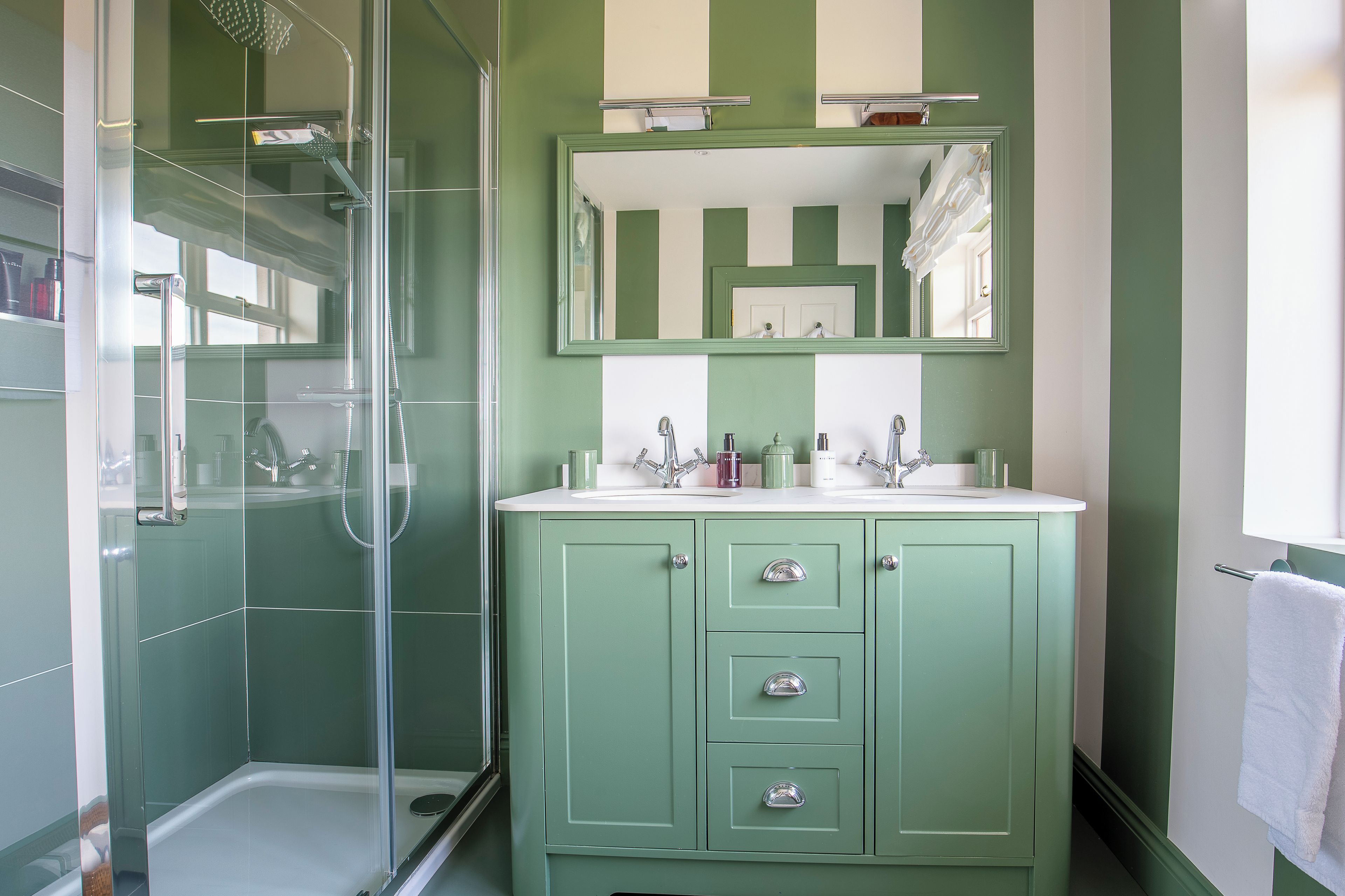 A bathroom with a shower, a sink, and a cabinet.