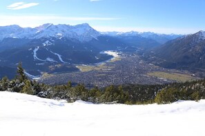 Eine gebirgige Landschaft mit einem Tal und einer Stadt.