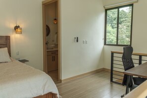 A bedroom with a bed, a desk, and a window. - Tropical Hideaway Loft (Playas Del Coco)