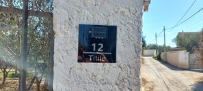 A house number 12 on a textured wall with a small window. - Titilè: a new and comfortable room, surrounded by greenery, with a private entrance (ALGHERO)