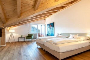 Ein Schlafzimmer mit einem großen Bett, einem Sessel, einer Lampe und einem Bild an der Wand.