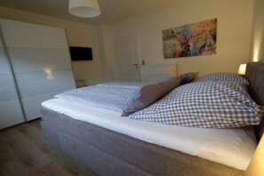 Ein Schlafzimmer mit einem Bett, einem Bild an der Wand und einem Kleiderschrank.