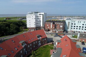 A hotel with multiple buildings, including a prominent white tower and a red-roofed structure. - Holiday apartment with 2 bedrooms (Norddeich)