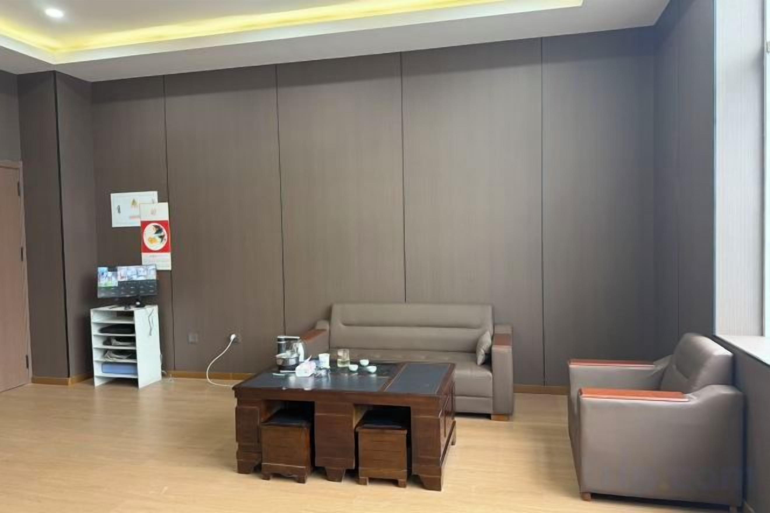 A modern living room with a sofa, a coffee table, and a chair. There is a small table with a few items on it.