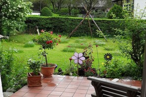 A garden with potted plants, a windmill, and a bench. - Holiday apartment with 2 bedrooms (Garmisch-Partenkirchen)