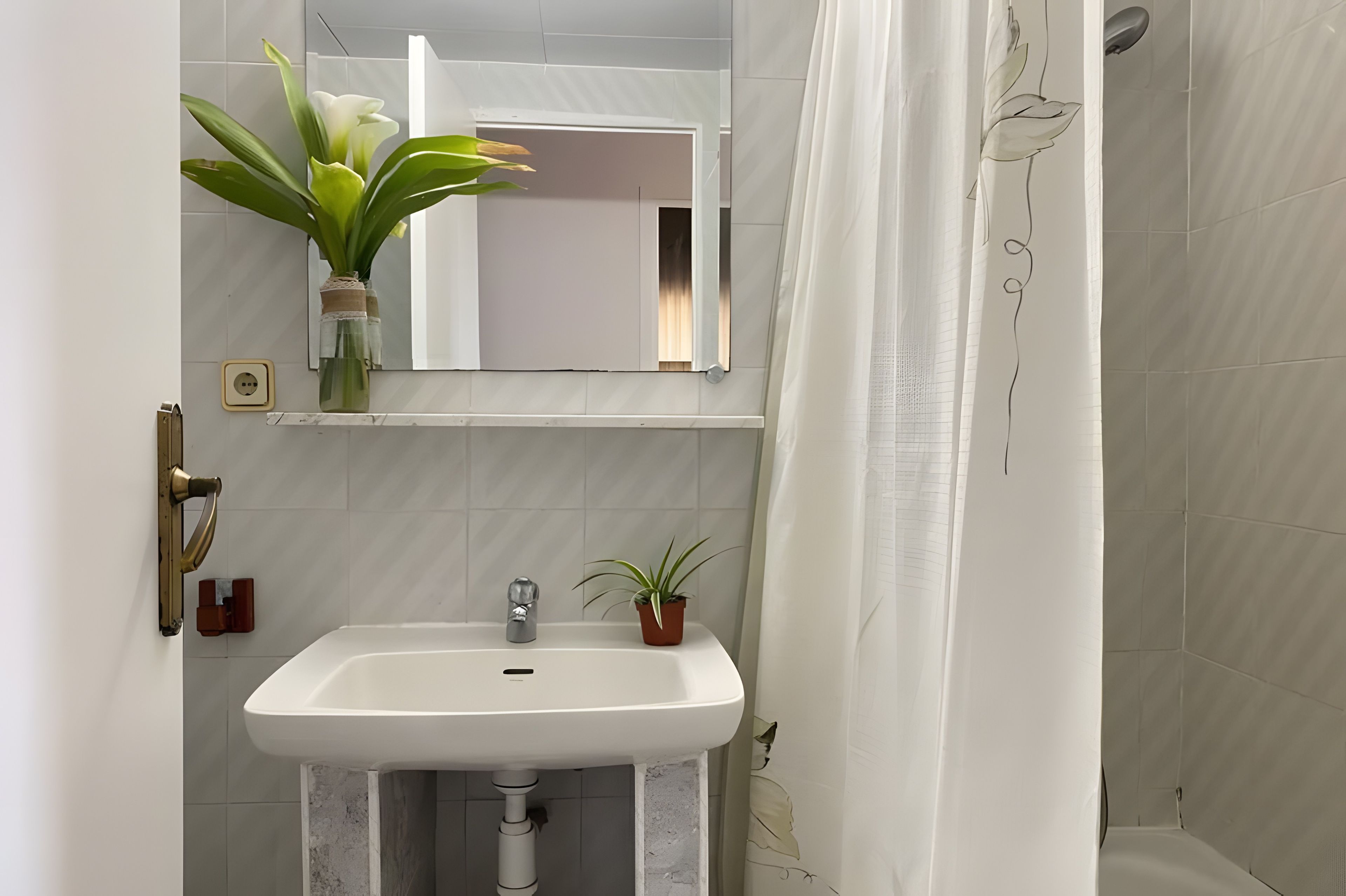 Un baño con un lavamanos blanco, un espejo, una planta en maceta y una cortina de ducha.