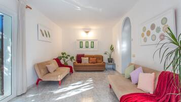 Una sala de estar con dos sofás, una mesa de centro y una planta en maceta.