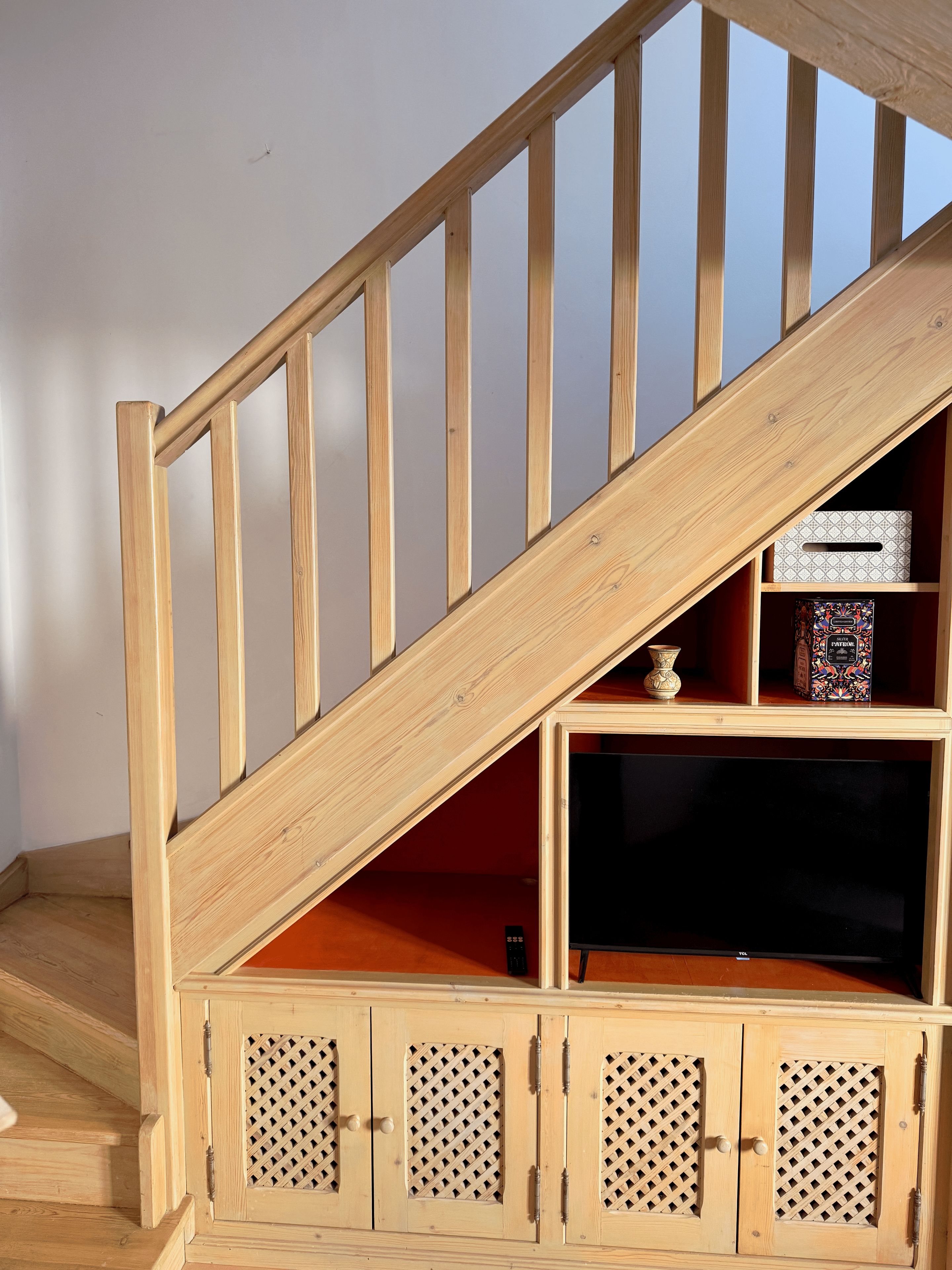Un escalier en bois avec un espace de rangement intégré en dessous.