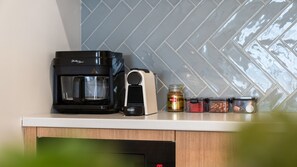 A kitchen with a coffee maker, a microwave, and a spice rack. - Seascape Studio in Terrigal (Terrigal)