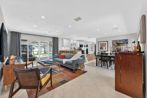 A modern living room with a sofa, coffee table, and dining area. - Sun, Pool & Sand- Fort Lauderdale Style Escape! (Fort Lauderdale)