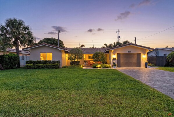 A single-story house with a garage, a well-maintained lawn, and a clear sky. - Sun, Pool & Sand- Fort Lauderdale Style Escape! (Fort Lauderdale)