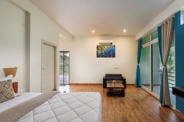 Une chambre d’hôtel avec un lit, un petit canapé, une table basse et un tableau au mur.
