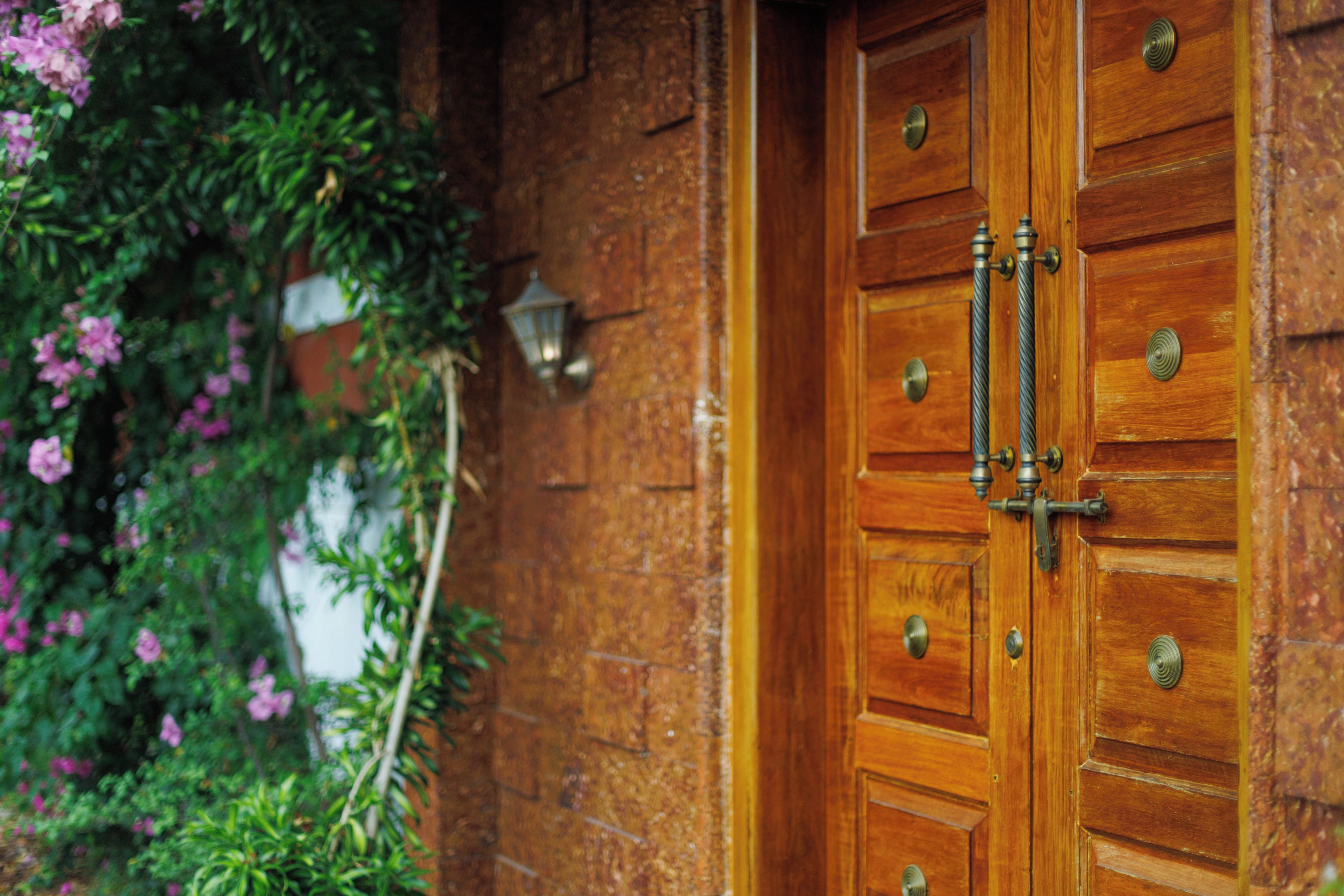 Una puerta de madera con manijas de latón y un cerrojo metálico.