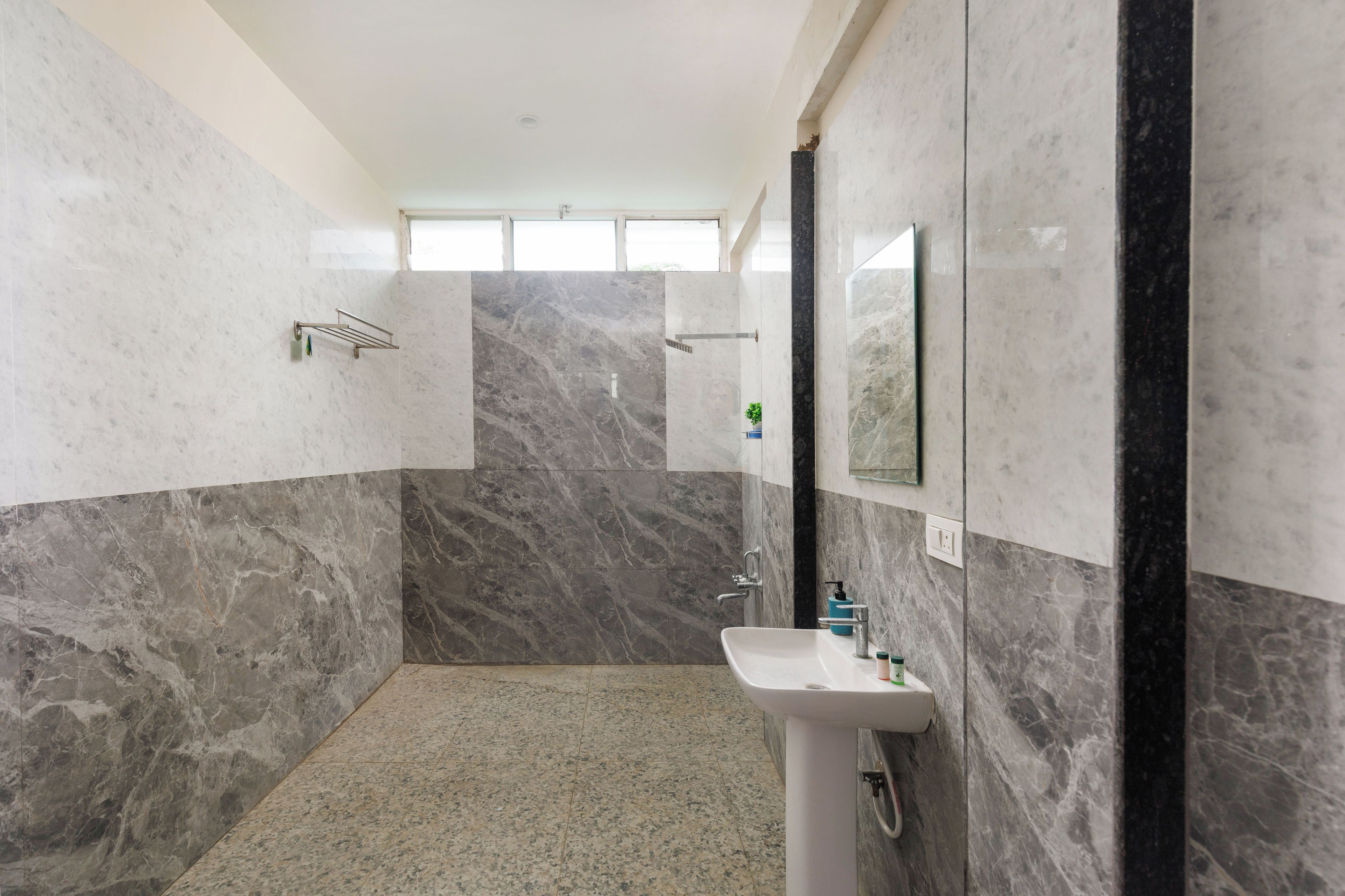 A bathroom with a sink, mirror, and shower area.