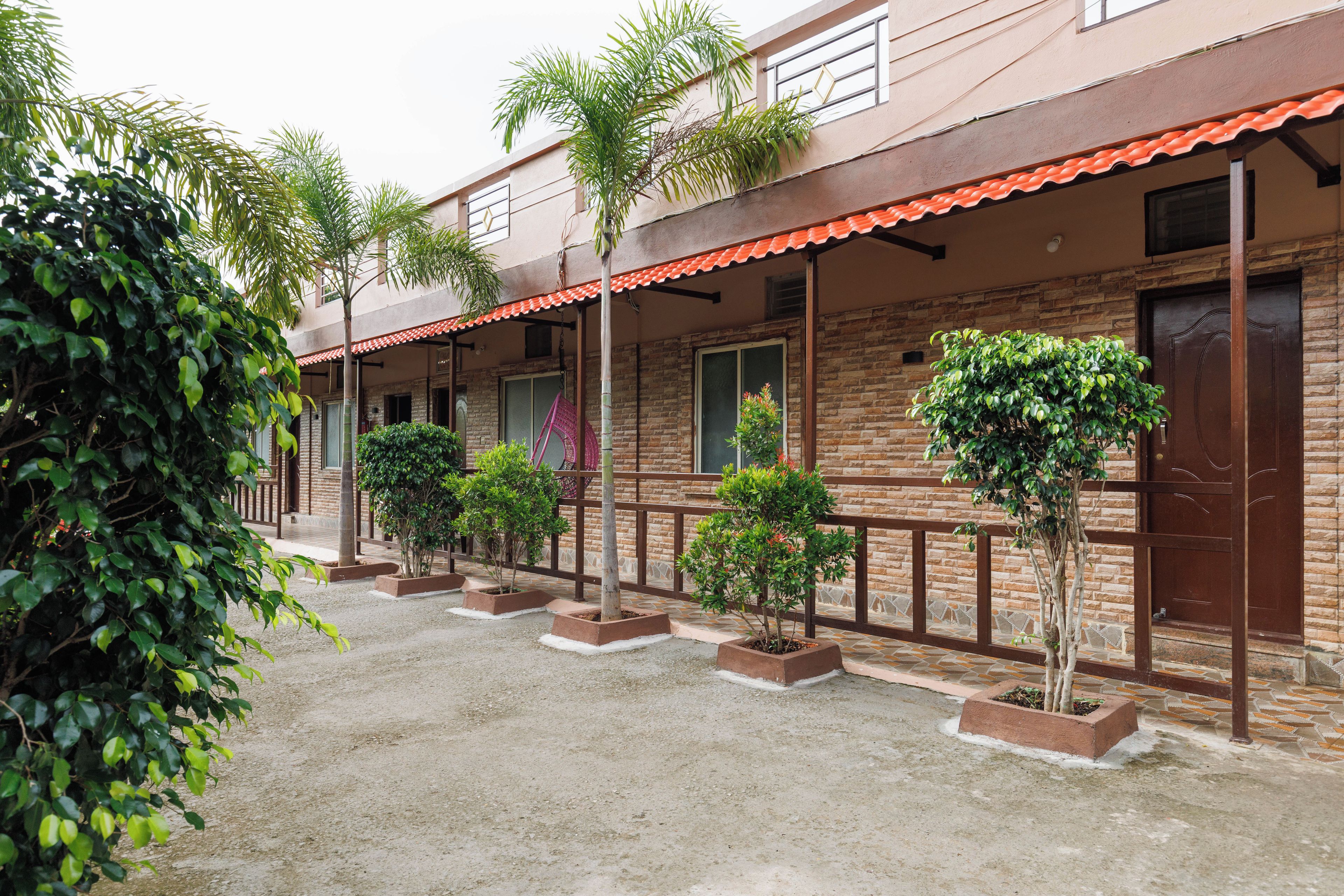 A building with a brick facade, multiple windows, and a covered walkway with planters.