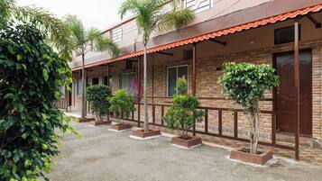 A building with a brick facade, multiple windows, and a covered walkway with planters.