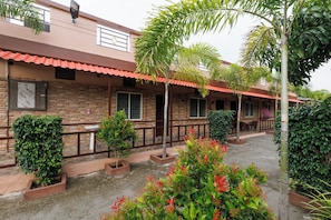 A building with a brick facade, multiple windows, and a tiled roof.