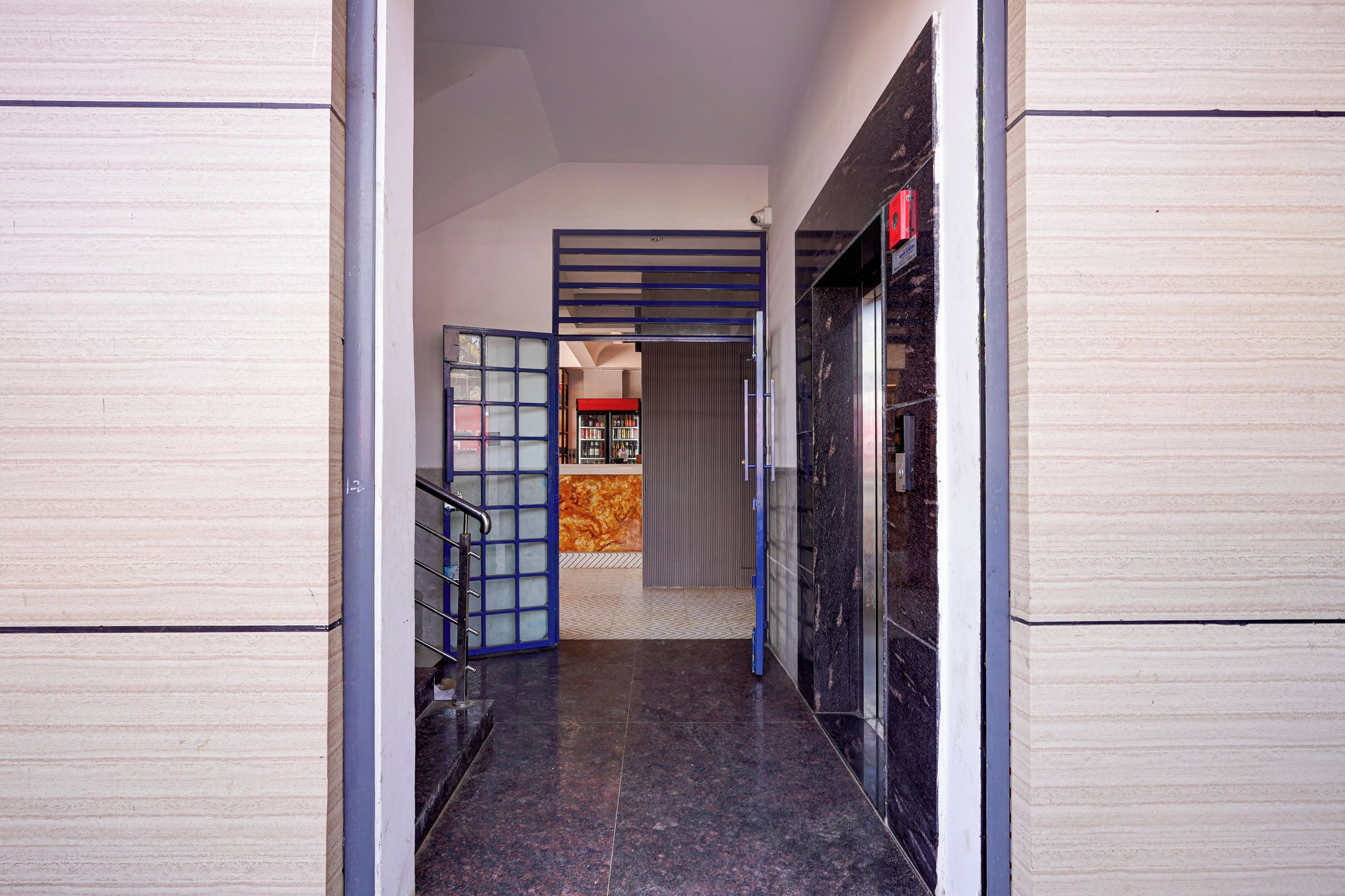 A hallway with a glass door, a staircase, and a vending machine.