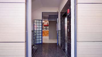A hallway with a glass door, a staircase, and a vending machine.