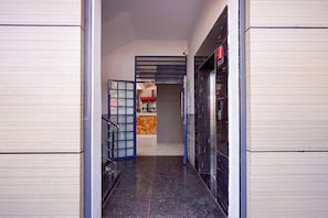 A hallway with a glass door, a staircase, and a vending machine. - Collection O Magadi Road Metro Station (Nelamangala)