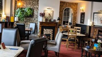 A cozy interior with a fireplace, stone walls, and comfortable seating areas.