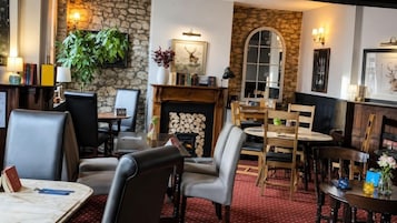 A cozy interior with a fireplace, stone walls, and comfortable seating areas.