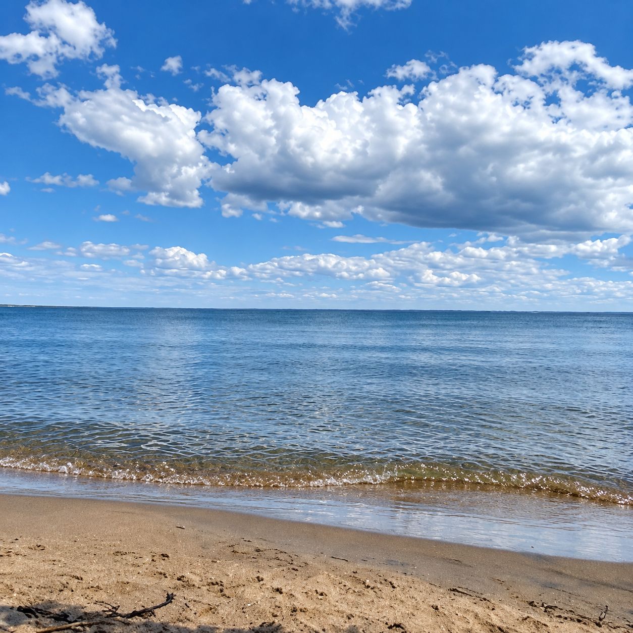 Una playa con cielos despejados y agua tranquila.