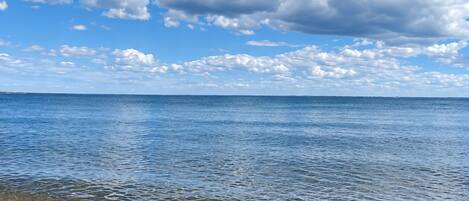 Una playa con cielos despejados y agua tranquila.