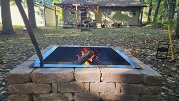 A fire pit with a brick surround in a wooded area.