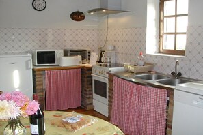 Eine kleine Küche mit Kühlschrank, Mikrowelle, Toaster und Spüle.