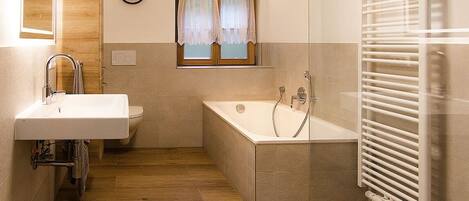 Un baño moderno con lavabo, inodoro y bañera.