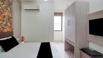 Une chambre d’hôtel équipée d’un lit, d’une armoire, d’un téléviseur à écran plat et d’un système de climatisation.